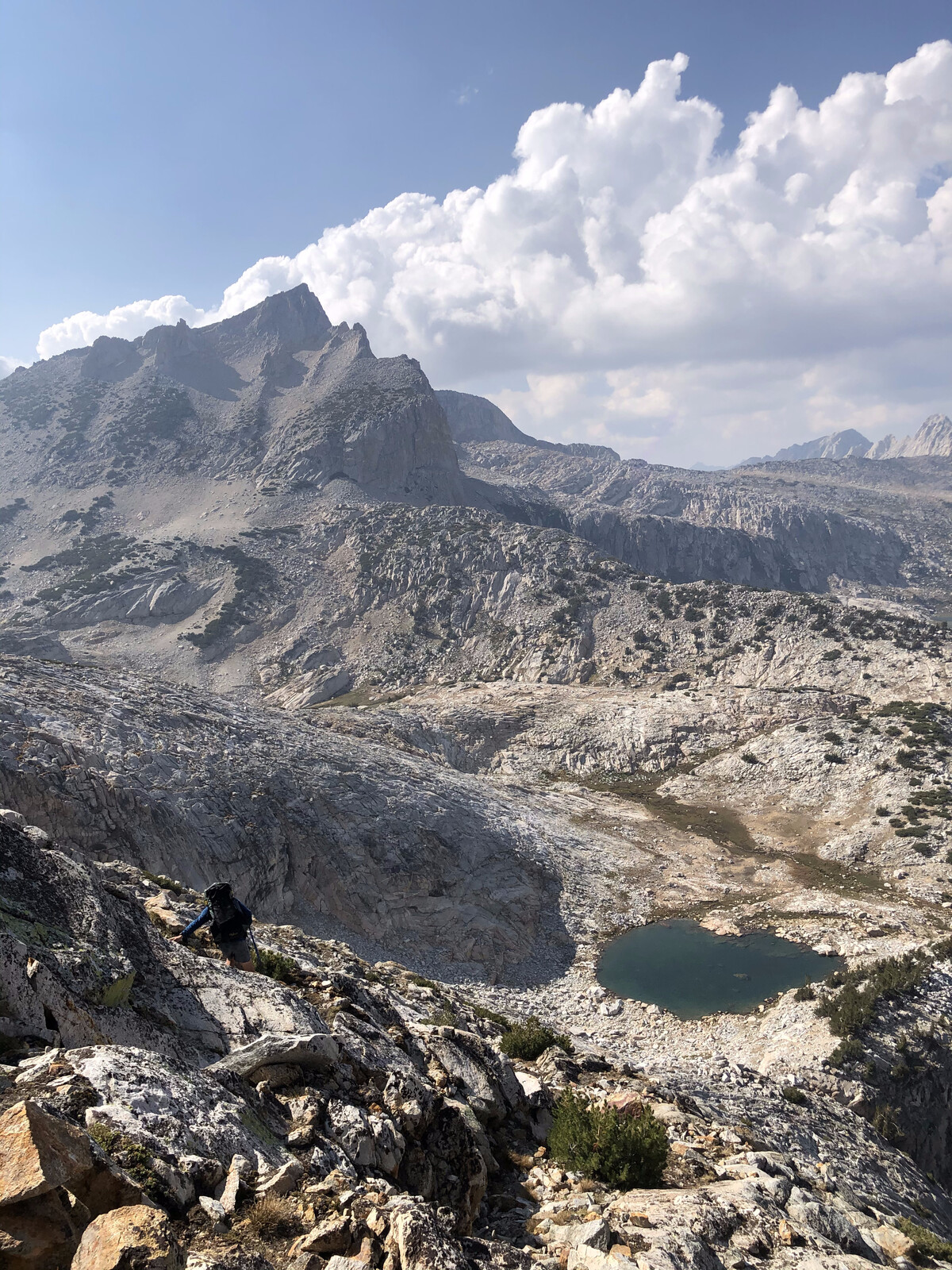 Deep alpine basin with turquoise lake and surrounding peaks