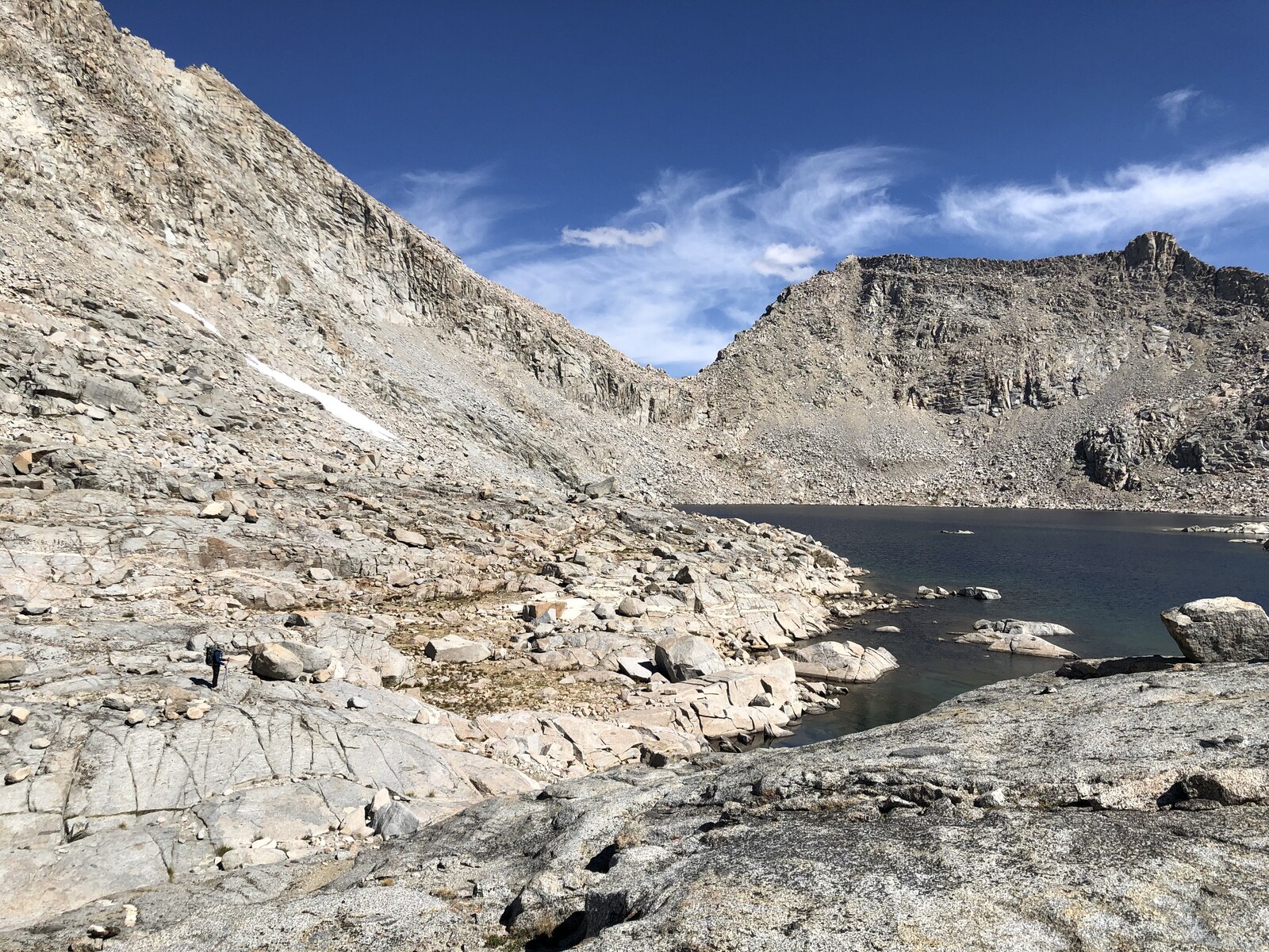 Rocky alpine lake shore with steep granite cirque walls