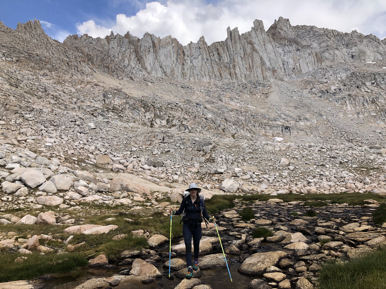 Hiker on talus exploring rocky alpine basin landscape
