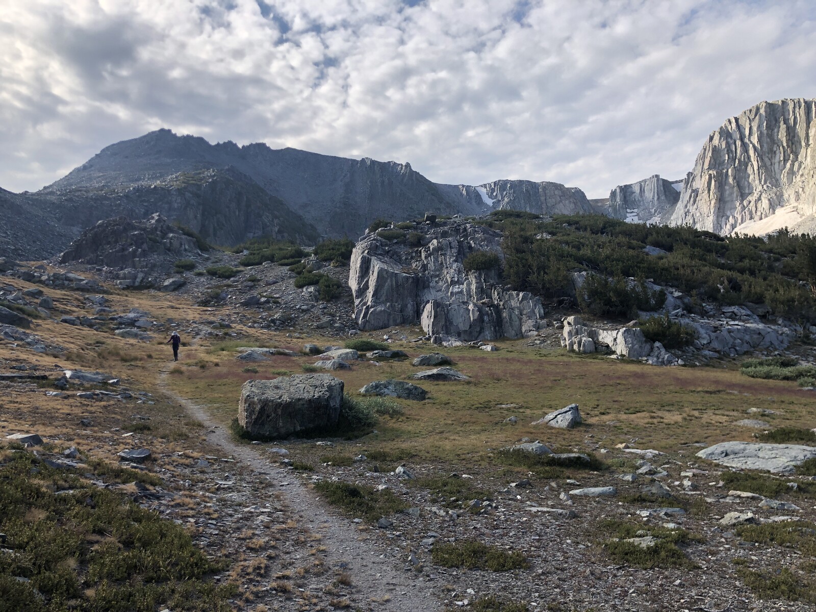 Rocky shoreline of turquoise alpine lake with steep walls