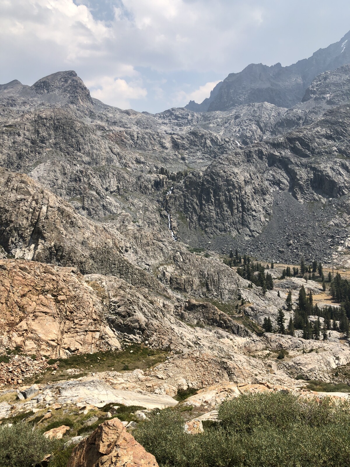 Steep rocky mountain face with cascading streams