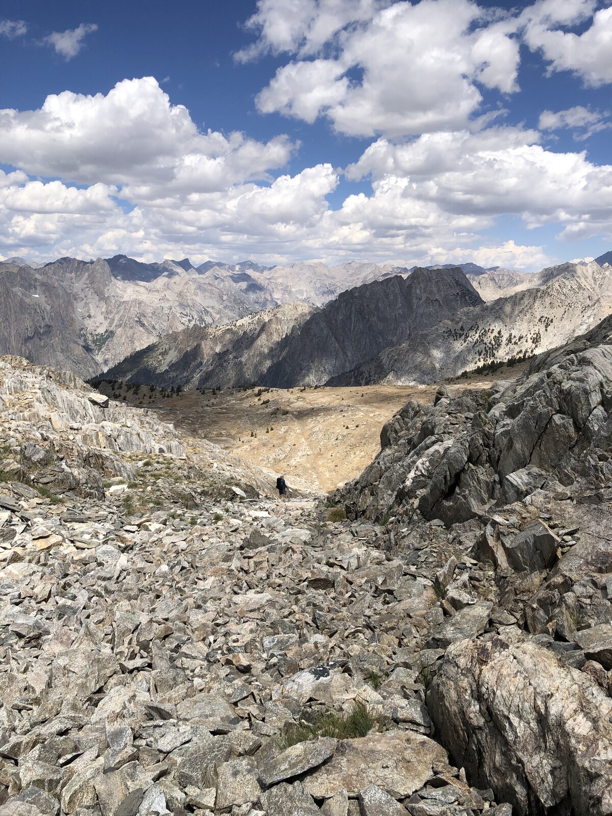 Rocky alpine plateau with scattered peaks and distant mountains