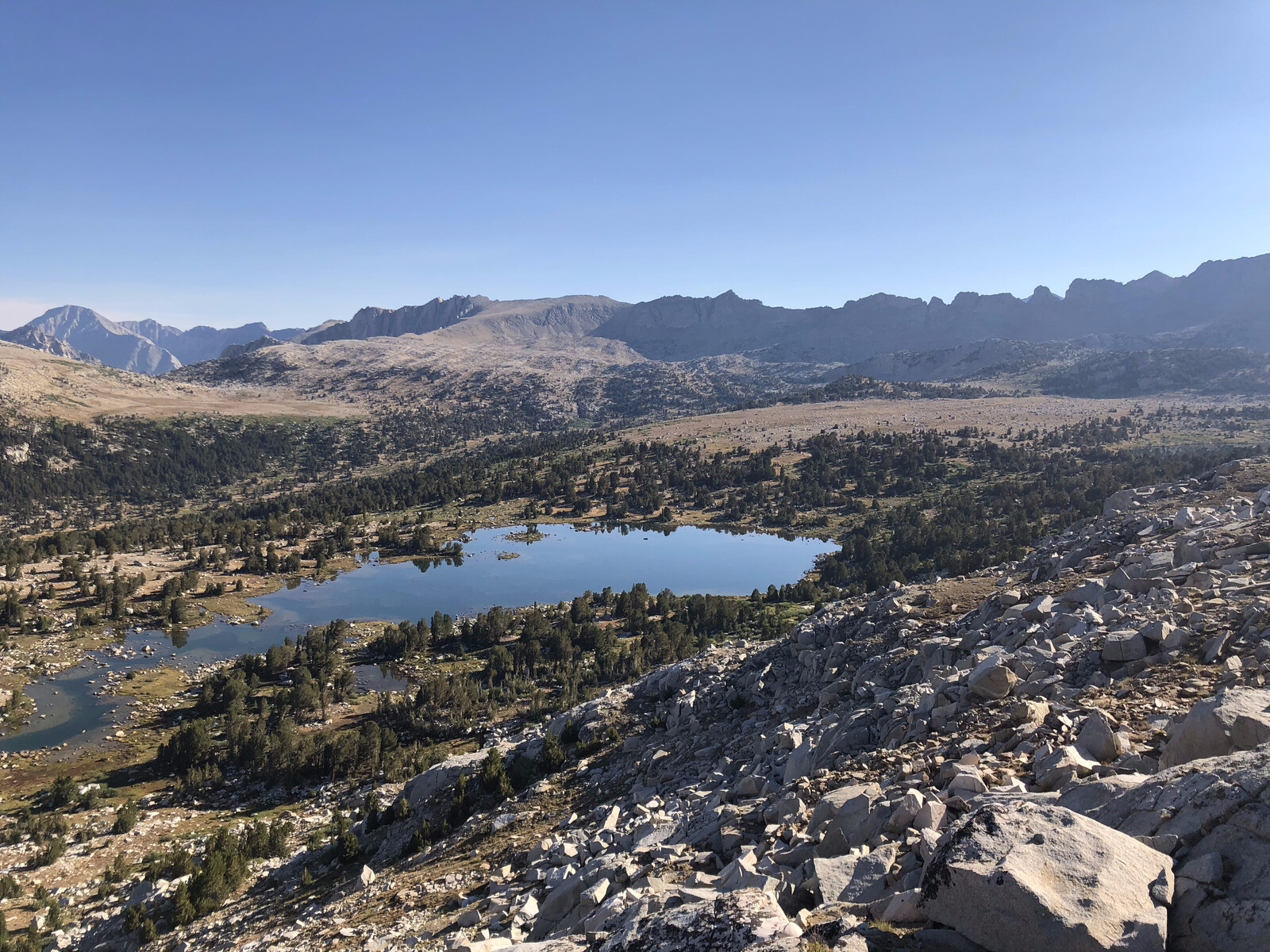 Expansive view of multiple alpine lakes in forested basin