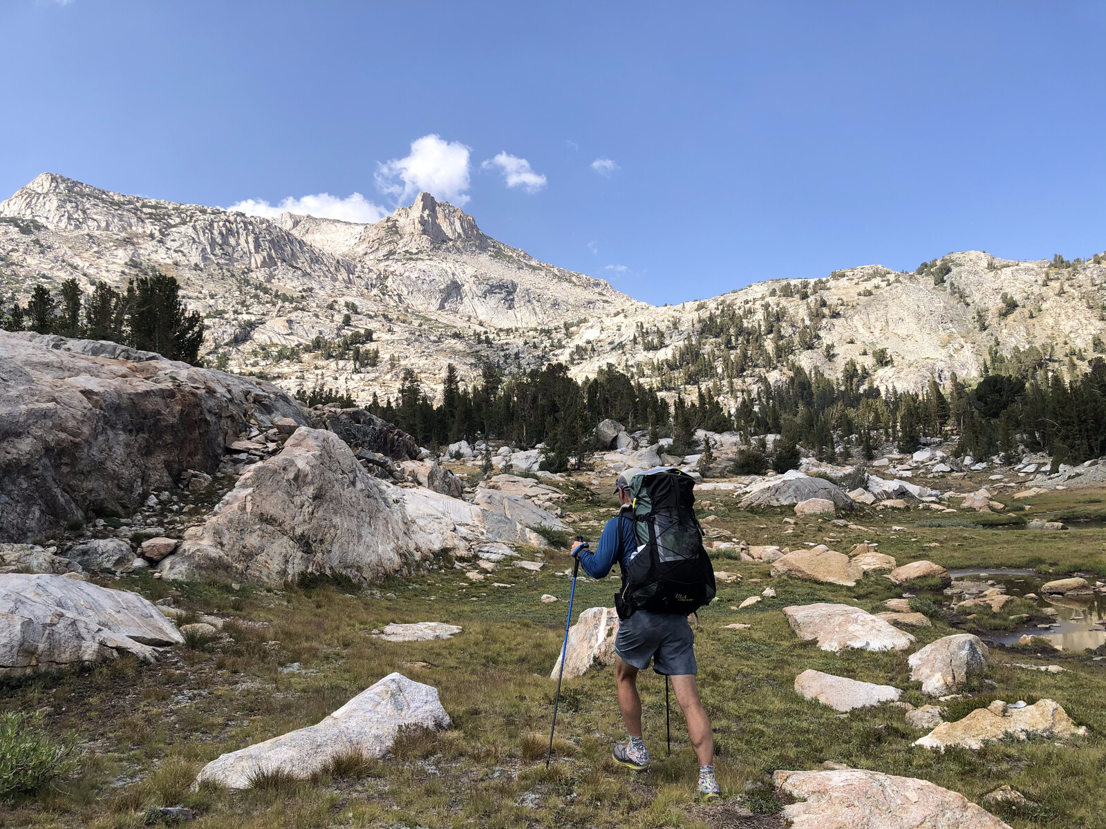 Hiker exploring diverse alpine terrain with multiple peaks