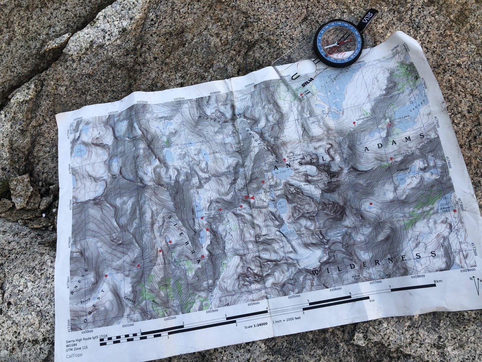 One of our paper maps and compass laid out on natural granite countertop