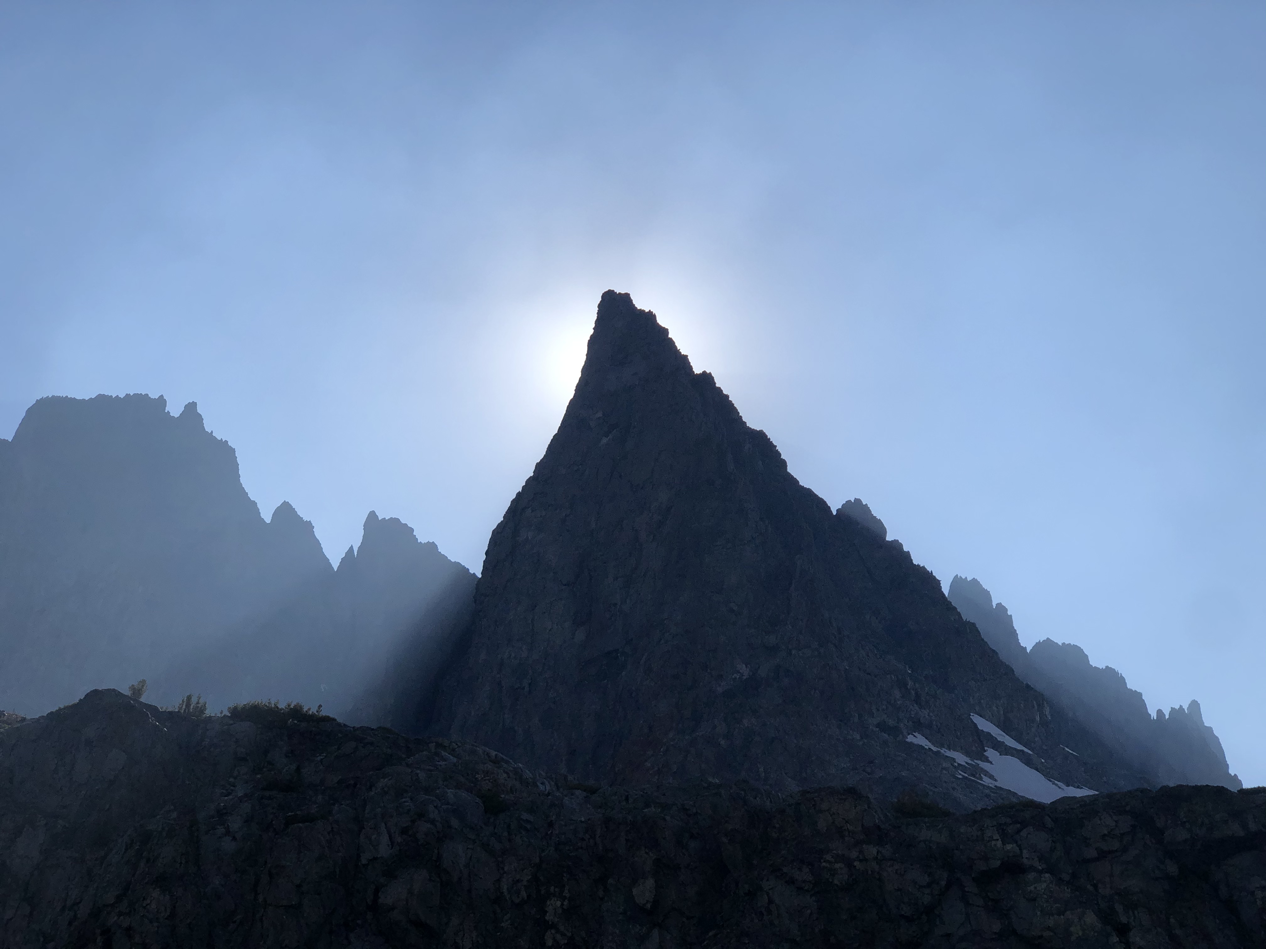 Sun setting behind a sharp peak